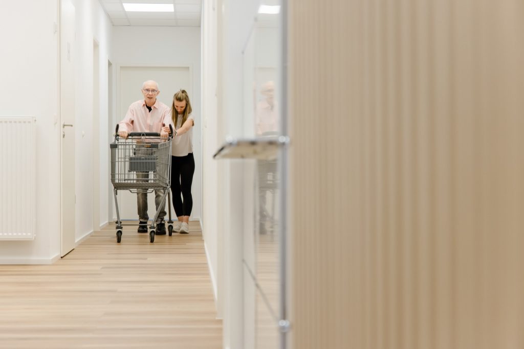 Klientin beim Gehtraining mit Rollator im Flur