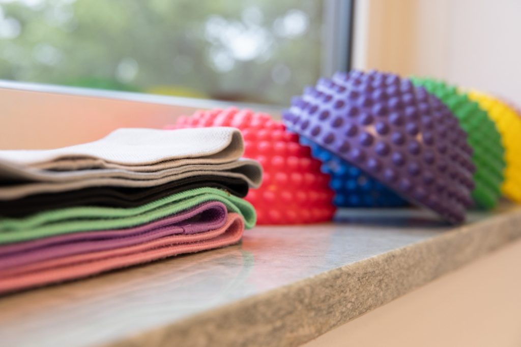 Buntes Therapiematerial - Igelbälle und Balance-Pads auf einer Fensterbank