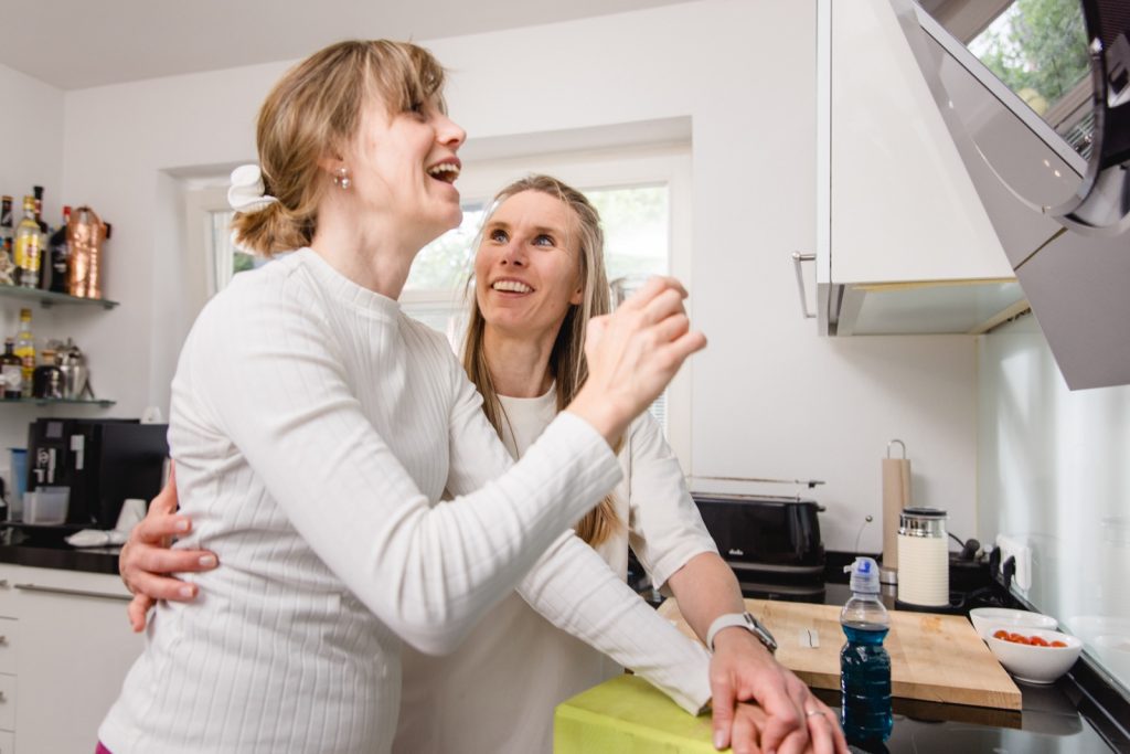 Therapeutin uebt mit einer Klientin eine Alltagsbewegung in der Kueche - Hausbesuch